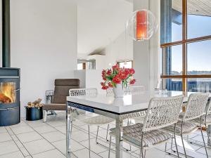 イェリングにある8 person holiday home in Hjørringのダイニングルーム(テーブル、椅子、暖炉付) +25枚の写真