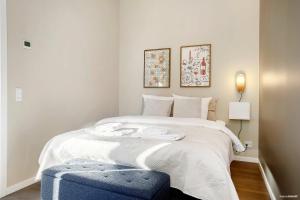 - une chambre avec un grand lit doté d'une ottomane bleue dans l'établissement Midtown Suite, à Aarhus