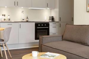 un salon avec un canapé et une table et une cuisine dans l'établissement Midtown Suite, à Aarhus 15 autres photos