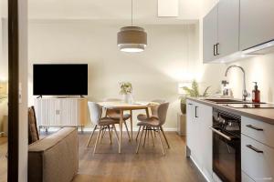 a kitchen and dining room with a table and a tv at Stylish Easy-Access Ground Floor Apartment for 4 in Aarhus