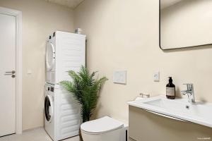 a bathroom with a white refrigerator and a sink at Stylish Easy-Access Ground Floor Apartment for 4 in Aarhus