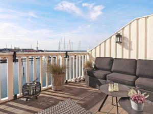 a balcony with a couch and a table and the water at 8 person holiday home in Bagenkop-By Traum in Bagenkop
