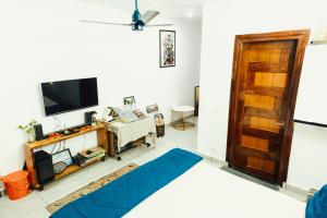 a room with a bed and a tv on a wall at JM Luxury Homestays in Jawāla Mukhi