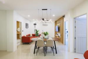 ein Esszimmer und ein Wohnzimmer mit Tisch und Stühlen in der Unterkunft Wink Hill 1 Penthouse Patong 4 Bedrooms in Patong Beach + 197 Fotos