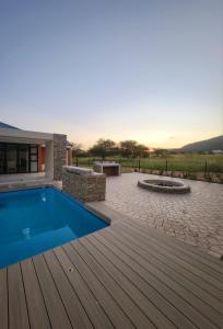 a backyard with a swimming pool and a wooden deck at Euphoria 447 in Naboomspruit