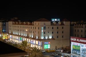a large building with a clock on top of it at night at شقق أعلي الثناء المخدومة -ELI ALTHANA Serviced Apartments in Yanbu