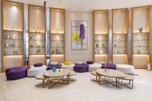 深セン市にあるLavande International Hotel Shenzhen Baoan Liantou Dongfang Park Branchの2つのテーブルと紫色の椅子と棚のある部屋