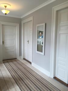 korytarz z białymi drzwiami i zdjęciem na ścianie w obiekcie Birkum BB w mieście Birkum
