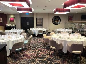 a dining room with white tables and chairs at DoubleTree by Hilton London – West End in London