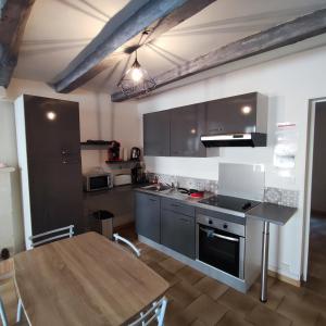 a kitchen with a wooden table and a dining room at centre historique T2 RDC in La Roche-Posay