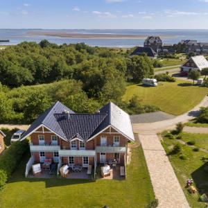 an aerial view of a house with the ocean in the background at Haus Wind&Wellen, Wohnung Leuchtturm in Wittdün