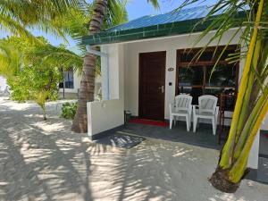 a house on the beach with a table and chairs at Lagoon View in Bodufolhudhoo