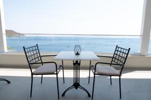 a white table with two chairs and a window at The Lakehouse in Límni