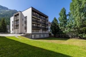 an apartment building with a large lawn in front of it at Hostel Casa Franco in St. Moritz