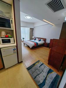 a living room with a bed and a kitchen and a room at East King Business Hotel (West Lake store, Hangzhou) in Hangzhou