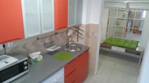 a kitchen with red and white cabinets and a sink at Universitate Residence in Bucharest