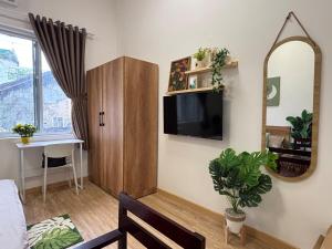 a living room with a tv and a mirror at Central room in district 1, 450m to Ben Thanh market in Kon Rung (1)