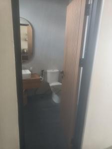 a bathroom with a toilet and a sink and a mirror at SecondHomeBali in Canggu