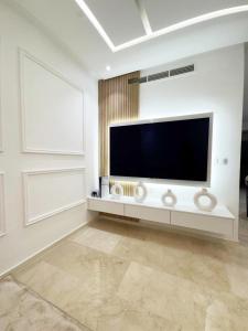 马拉喀什Appartement de Luxe 3 Chambres avec piscine au centre的客厅配有壁挂式大屏幕平面电视