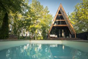 a swimming pool with a house in the background at Meszes Twins in Kalocsa +27 photos