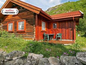 a log cabin with two chairs and a table outside at 5 person holiday home in Hemsedal-By Traum in Hemsedal