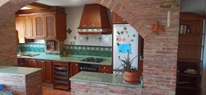 a kitchen with a white refrigerator and a brick wall at Casa Paola in Buñol
