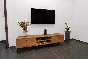a wooden entertainment center with a flat screen tv on a wall at Central 2 Bdr Flat St Lazaros - Phoenix Lodge in Larnaka