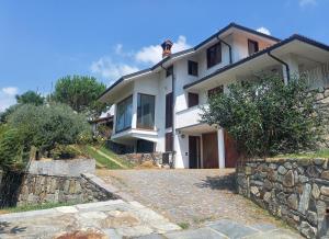 a large white house with a stone wall at Villa Sigerico apartment in Ivrea