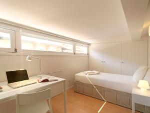 a bedroom with a bed and a desk with a laptop at Uporto House Villa in Porto
