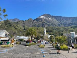 a street with a mountain in the background with people on skateboards at Appartement entier Saint Pierre Centre dans résidence de prestige in Saint-Pierre