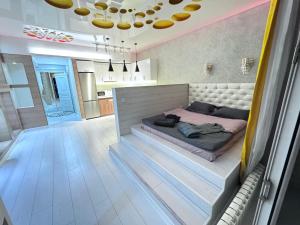 a bedroom with a bed in the middle of a room at Уютная квартира in Almaty