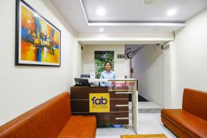 a woman sitting at a reception desk in a waiting room at FabHotel Sanskar in Bhopal