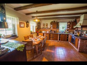 a kitchen with a table and chairs in a room at Zagroda u Macieja in Ustka