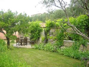 un jardin avec une table, des chaises et des arbres dans l'établissement Mas de Vence - Hotel-Restaurant, à Vence