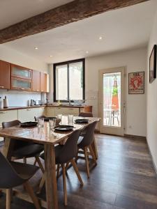 a kitchen and dining room with a wooden table and chairs at Maison 4 pers, calme et confort in Opoul-Périllos