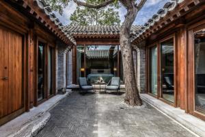 un patio con 2 sedie, un tavolo e un albero di Mandarin Oriental Qianmen, Beijing a Pechino