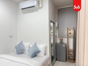 a bedroom with a bed with pillows and a tv at Happy One-Bedroom Stay in Hat Yai in Ban Thung Ngai