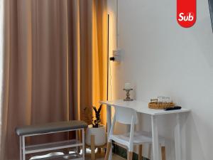 a table and two chairs in a room with a table and a curtain at Happy One-Bedroom Stay in Hat Yai in Ban Thung Ngai +16 photos