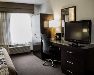 a hotel room with a desk with a television and a bed at Sleep Inn in Johnstown