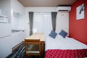 een slaapkamer met een bed en een tafel en een keuken bij Noir Toji Inn in Kyoto