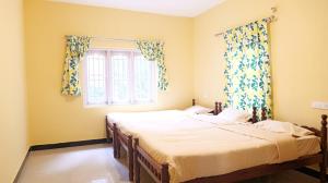 two beds in a room with a window at Happy Villa By Eden Luxury Stay in Ooty