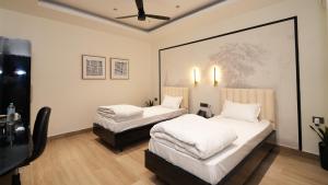 Un dormitorio con dos camas y un televisor. en Hotel Kuber, en Guwahati