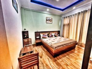 ein Schlafzimmer mit einem Bett und einem Holzboden in der Unterkunft Baldeyan Breeze - 2BHK Apartments - Private Balcony in Shimla