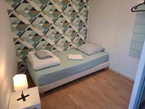 a small room with a bed with a geometric wall at Gîte Le petit Migron 6 personnes in Frossay