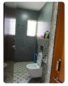 a bathroom with a toilet and a shower at HarshYog Homestay in Nashik