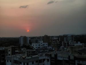 a view of a city with the sunset in the background at HarshYog Homestay in Nashik