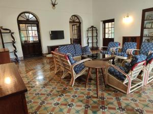 a lobby with chairs and a table and a tv at The Estate Bay by Z Vacations in Gonikoppal