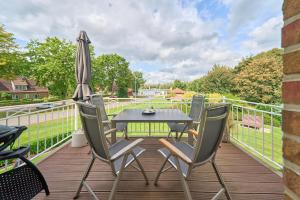 a patio with a table and chairs and an umbrella at Villa Kanalblick, Ausguck in Oldenbüttel