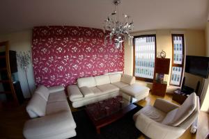 un soggiorno con mobili bianchi e una parete rossa di Sea Towers Gdynia a Gdynia