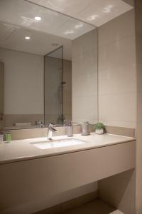 a bathroom with a sink and a mirror at Cool Summer Gateway At Yas in Abu Dhabi